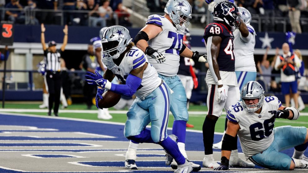 Dallas Cowboys running back Ezekiel Elliott (21) scores a touchdown during the second half of an NFL football game against the Houston Texans, Sunday, Dec. 11, 2022, in Arlington, Texas. (AP Photo/Michael Ainsworth)