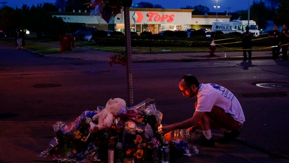 A person pays his respects outside the scene of a shooting at a supermarket, in Buffalo, N.Y., Sunday, May 15, 2022. (AP Photo/Matt Rourke)