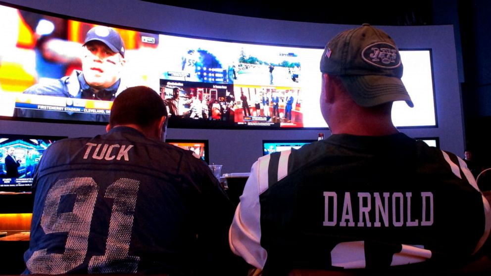 FILE - This Sept. 9, 2018 file photo shows fans of the New York Giants and Jets watching a football game after placing bets in the sports betting lounge at the Ocean Casino Resort in Atlantic City, N.J. The American Gaming Association estimates more 
