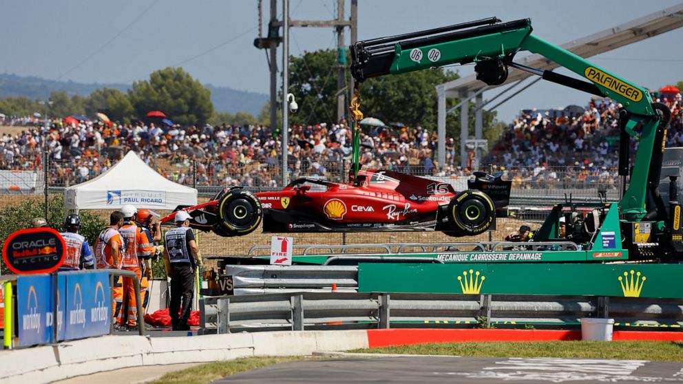 Track marshals remove car of Ferrari driver Charles Leclerc of Monaco after he crashed into the track wall during the French Formula One Grand Prix at Paul Ricard racetrack in Le Castellet, southern France, Sunday, July 24, 2022. (Eric Gaillard/Pool 