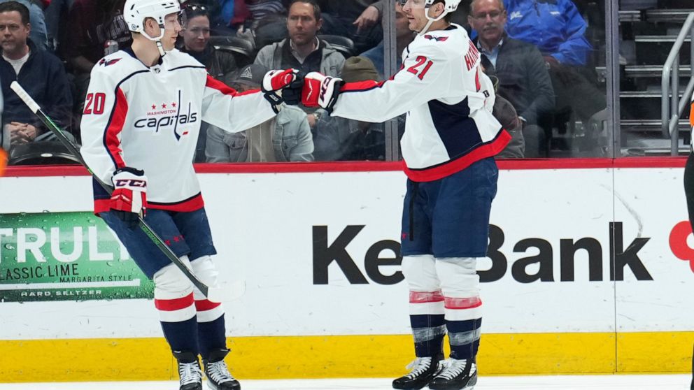 Washington Capitals right wing Garnet Hathaway (21) celebrates a goal against the Colorado Avalanche with teammate Lars Eller (20) during the first period of an NHL hockey game Monday, April 18, 2022, in Denver. (AP Photo/Jack Dempsey)