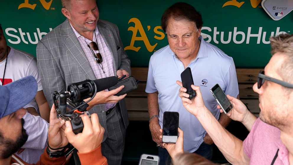 Chicago White Sox manager Tony La Russa, back right, talks to reporters in the dugout before a baseball game against the Oakland Athletics in Oakland, Calif., Sunday, Sept. 11, 2022. (AP Photo/Godofredo A. Vásquez)