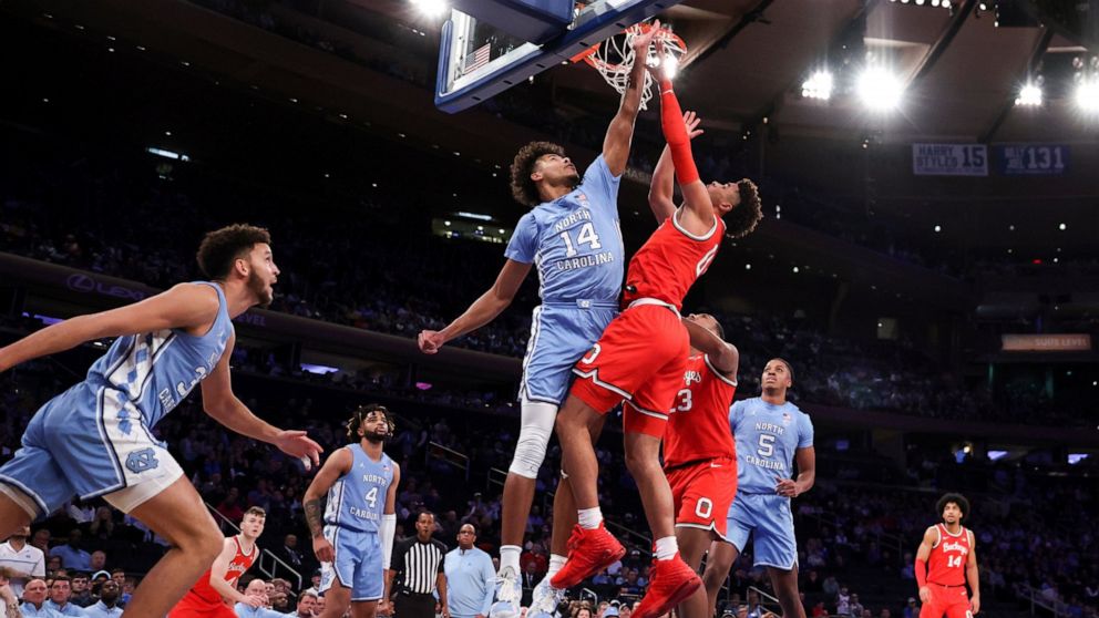 North Carolina forward Puff Johnson (14) attempts to block Ohio State guard Tanner Holden during the first half of an NCAA college basketball game in the CBS Sports Classic, Saturday, Dec. 17, 2022, in New York. (AP Photo/Julia Nikhinson)