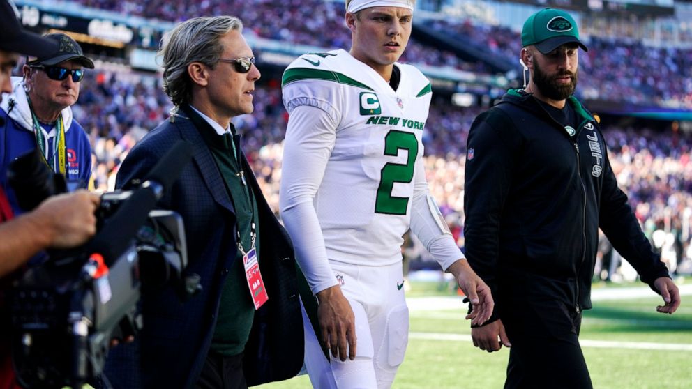 New York Jets quarterback Zach Wilson (2) is escorted to the locker room after an apparent injury during the first half of an NFL football game against the New England Patriots, Sunday, Oct. 24, 2021, in Foxborough, Mass. (AP Photo/Steven Senne)