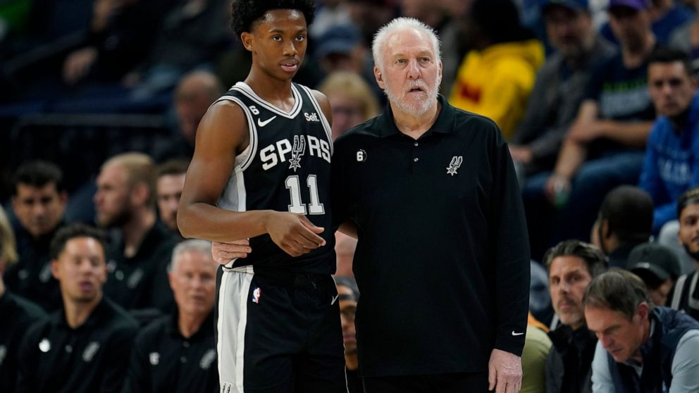 San Antonio Spurs guard Joshua Primo (11) and head coach Gregg Popovich watch play during the first half of an NBA basketball game against the Minnesota Timberwolves, Monday, Oct. 24, 2022, in Minneapolis. (AP Photo/Abbie Parr)