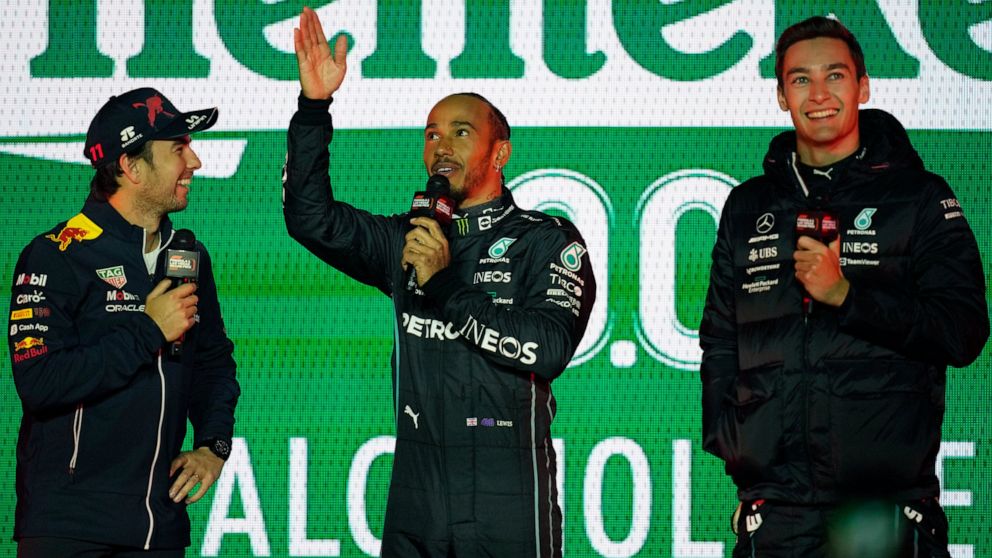From left to right, Sergio Perez, Lewis Hamilton and George Russell stand on stage at a launch party for the Formula One Las Vegas Grand Prix, Saturday, Nov. 5, 2022, in Las Vegas. (AP Photo/John Locher)