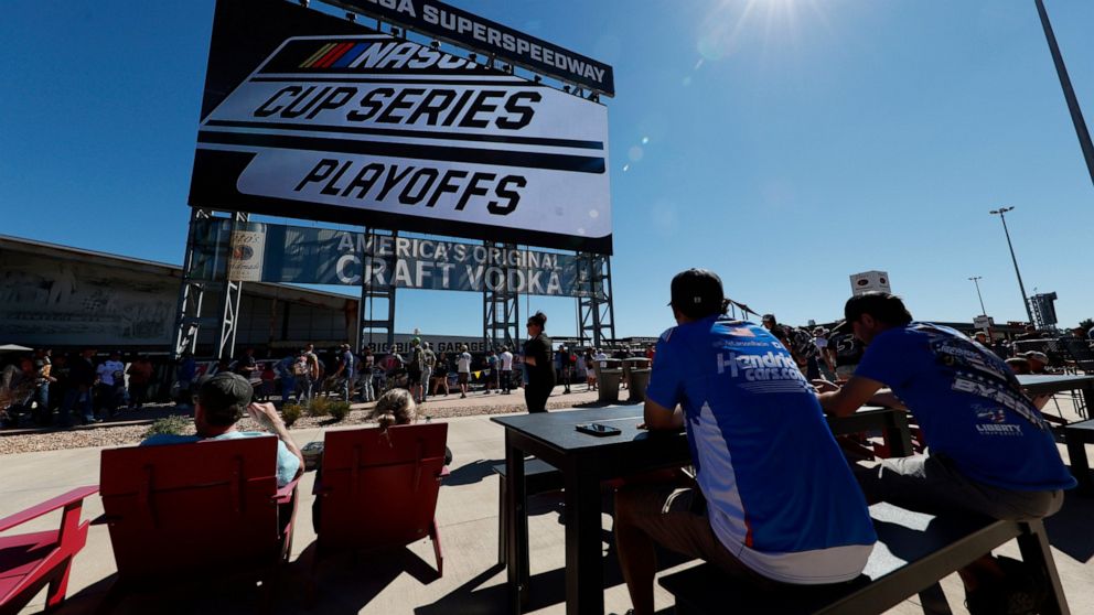 Fans eat and watch the big screen before the NASCAR Cup Series auto race Sunday, Oct. 2, 2022, in Talladega, Ala. (AP Photo/Butch Dill)