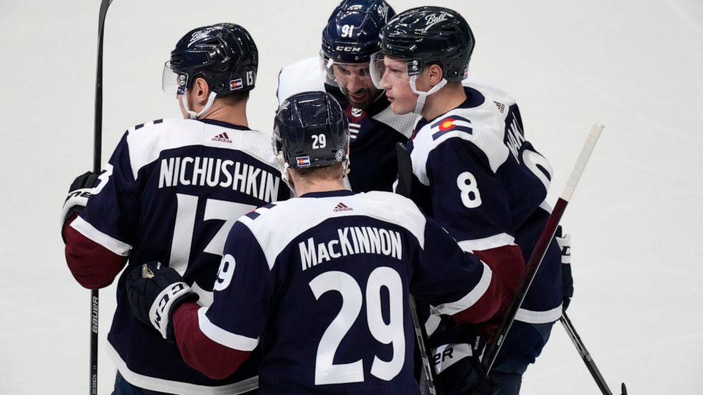 Colorado Avalanche defenseman Cale Makar, right, is congratulated by right wing Valeri Nichushkin, left, center Nathan MacKinnon, front center, and center Nazem Kadri for Makar's goal during the first period of an NHL hockey game against the Nashvill