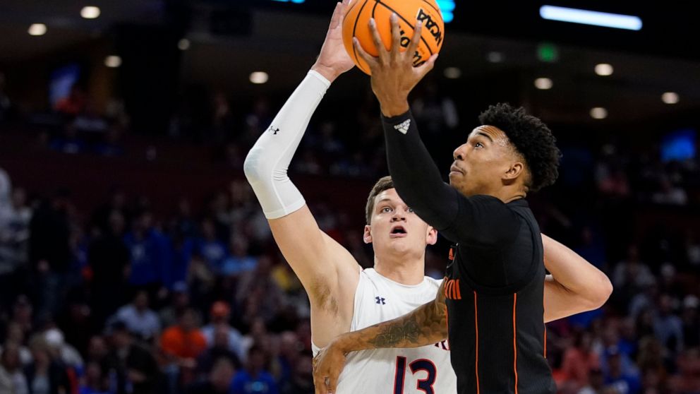Miami guard Jordan Miller shoots past Auburn forward Walker Kessler during the first half of a college basketball game in the second round of the NCAA tournament on Sunday, March 20, 2022, in Greenville, S.C. (AP Photo/Chris Carlson)