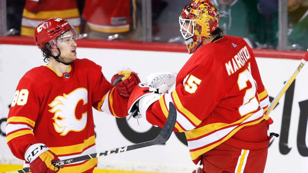 Calgary Flames left wing Andrew Mangiapane (88) and goaltender Jacob Markstrom (25) celebrate defeating the Dallas Stars in Game 5 of an NHL hockey Stanley Cup first-round playoff series, Wednesday, May 11, 2022 in Calgary, Alberta. (Larry MacDougal/