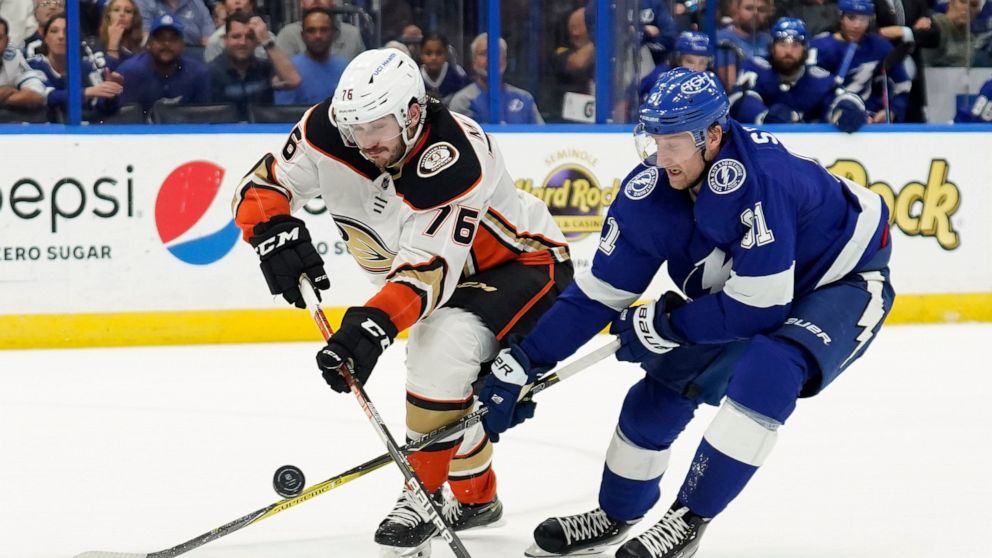 Anaheim Ducks defenseman Josh Mahura (76) knocks the puck away from Tampa Bay Lightning center Steven Stamkos (91) during the second period of an NHL hockey game Thursday, April 14, 2022, in Tampa, Fla. (AP Photo/Chris O'Meara)