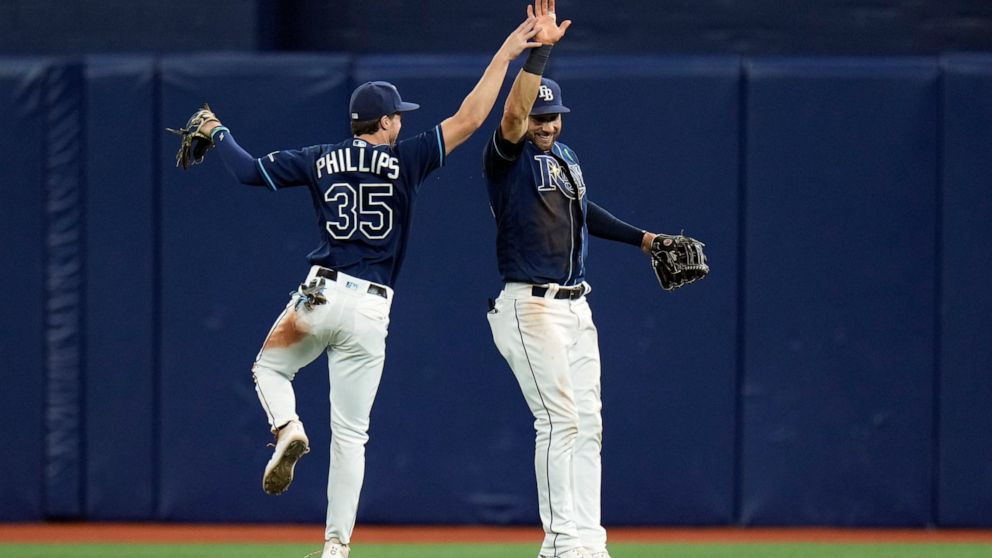 Tampa Bay Rays right fielder Brett Phillips (35) and center fielder Kevin Kiermaier (39) celebrate after the team defeated the Detroit Tigers during a baseball game Tuesday, May 17, 2022, in St. Petersburg, Fla. (AP Photo/Chris O'Meara)