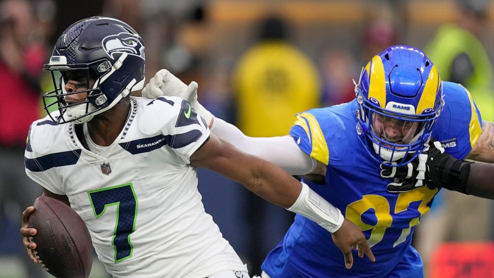 Los Angeles Rams defensive tackle Michael Hoecht (97) sacks Seattle Seahawks quarterback Geno Smith (7) during the first half of an NFL football game Sunday, Dec. 4, 2022, in Inglewood, Calif. (AP Photo/Mark J. Terrill)