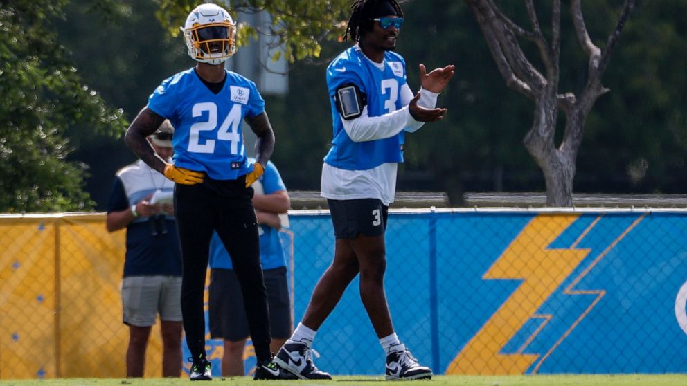 Los Angeles Chargers safeties Derwin James Jr. right, applauds next to Nasir Adderley (24) during the NFL football team's training camp Wednesday, July 27, 2022, in Costa Mesa, Calif. (AP Photo/Ringo H.W. Chiu)