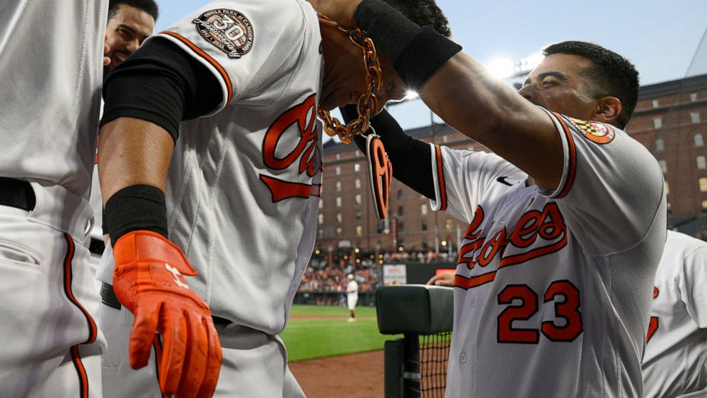Baltimore Orioles' Ryan Mountcastle, left, gets the home run chain from Robinson Chirinos, right, as he celebrates after his home run during the third inning of a baseball game against the Toronto Blue Jays, Monday, Aug. 8, 2022, in Baltimore. (AP Ph
