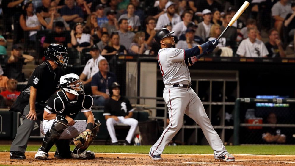 Minnesota Twins' Nelson Cruz watches his two run home run during the fifth inning of a baseball game as Chicago White Sox catcher James McCann (33) and home plate umpire Ed Hickox (15) look on Thursday, July 25, 2019, in Chicago. It was Cruz's third 