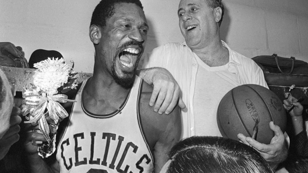 FILE - Boston Celtics' Bill Russell, left, holds a corsage sent to the dressing room as he celebrates with Celtics coach Red Auerbach after defeating the Los Angeles Lakers, 95-93, to win their eighth-straight NBA Championship, in Boston, in this Apr
