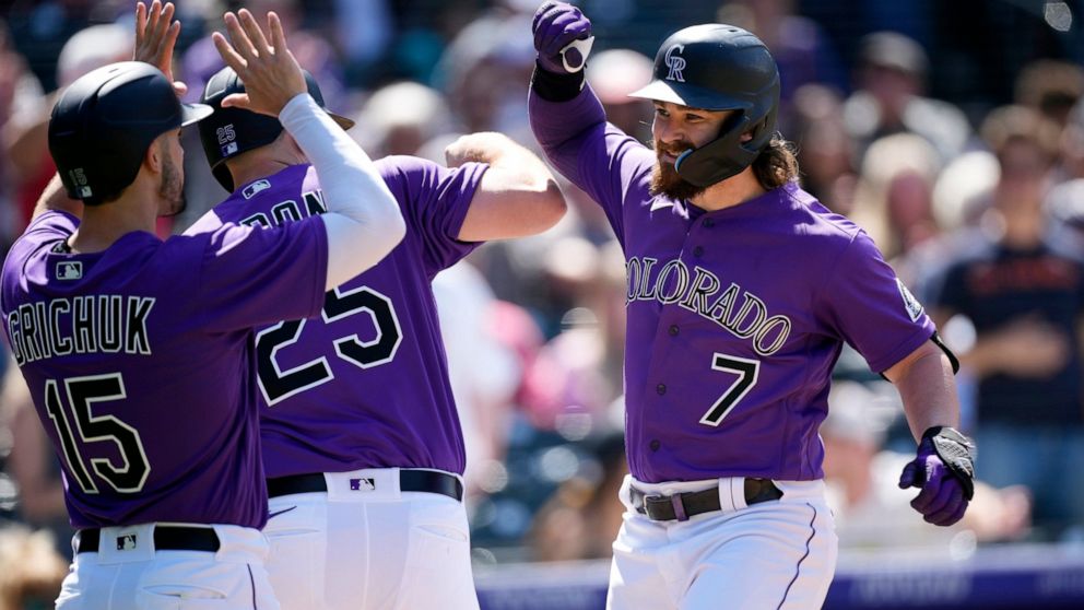 Colorado Rockies' Brendan Rodgers, right, celebrates with C.J. Cron, center, and Randal Grichuk after after hitting a three-run home run in the fifth inning of a baseball game against the Washington Nationals, Thursday, May 5, 2022, in Denver. (AP Ph