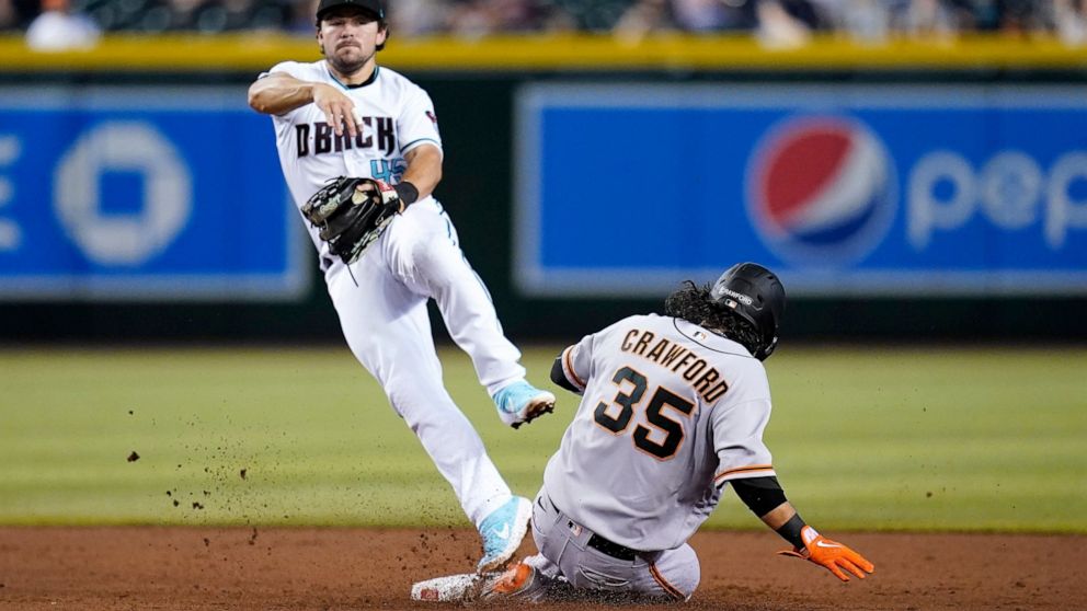 Arizona Diamondbacks second baseman Buddy Kennedy throws to first base for a double play after forcing out San Francisco Giants' Brandon Crawford (35) at second base during the third inning of a baseball game Tuesday, July 5, 2022, in Phoenix. (AP Ph