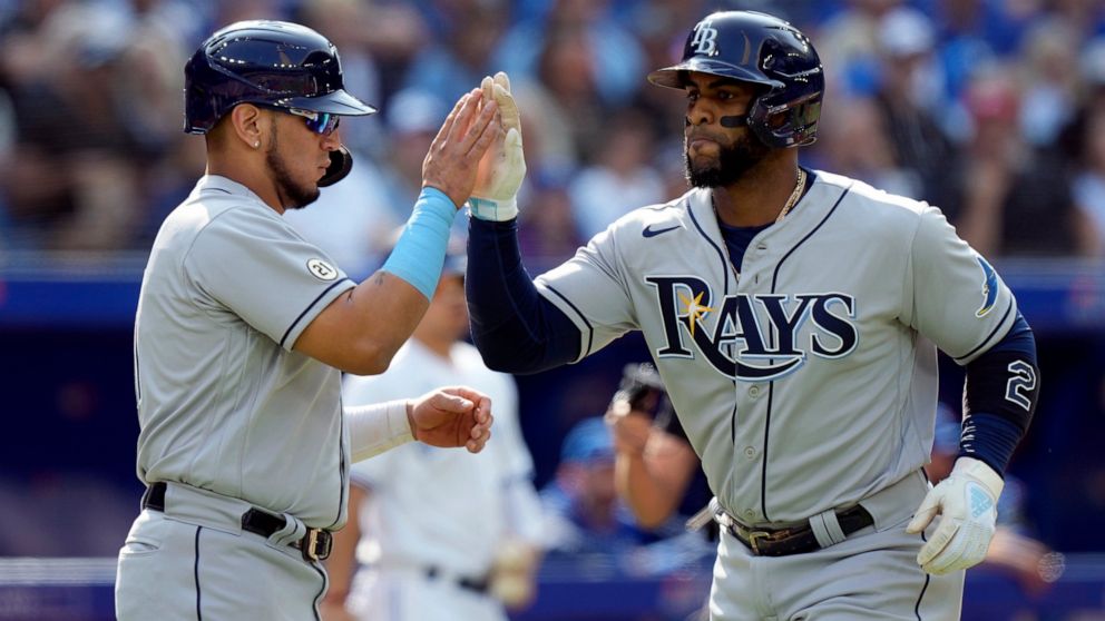 Tampa Bay Rays third baseman Isaac Paredes, left, congratulates teammate Yandy Diaz after scoring on a three run home-run by Diaz during the second inning of a baseball game in Toronto, Thursday, Sept. 15, 2022. (Frank Gunn/The Canadian Press via AP)