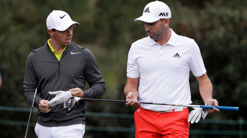 FILE - Rory McIlroy, left, of Northern Ireland, and Sergio Garcia, of Spain, walk up the 15th fairway during a practice round for the Masters golf tournament April 5, 2017, in Augusta, Ga. McIlroy, in a lengthy interview in the Sunday Independent in 