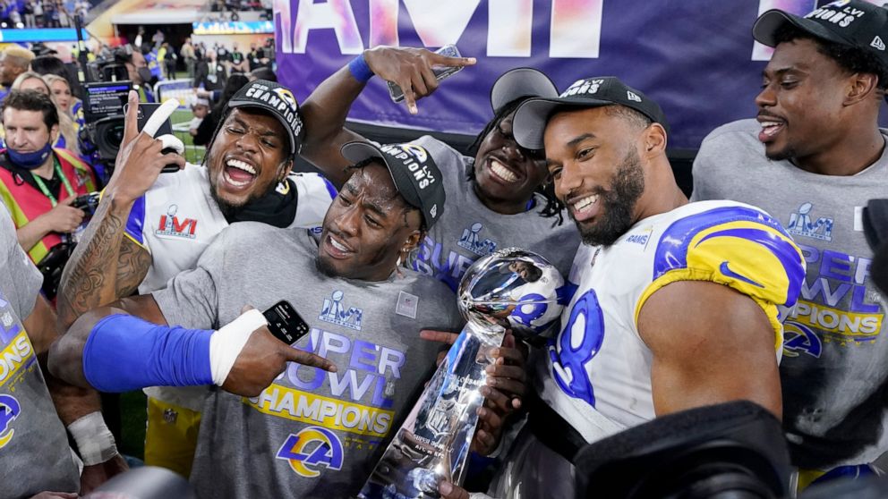 FILE - Los Angeles Rams players celebrate with the Lombardi Trophy after defeating the Cincinnati Bengals in the NFL Super Bowl 56 football game Sunday, Feb. 13, 2022, in Inglewood, Calif. The defending Super Bowl champion Los Angeles Rams host the B