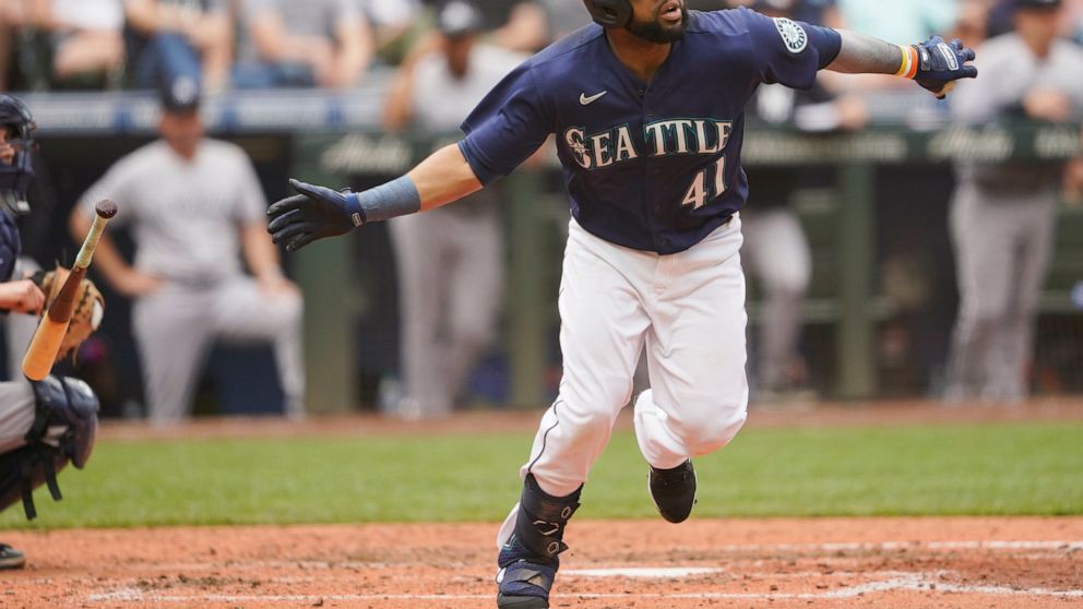 Seattle Mariners' Carlos Santana tosses his bat after hitting a two-run home run against the New York Yankees during the seventh inning of a baseball game, Wednesday, Aug. 10, 2022, in Seattle. (AP Photo/Ted S. Warren)