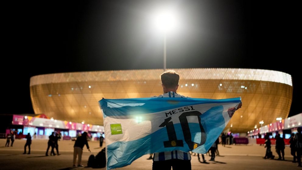 A man holds an Argentinian flag prior to the World Cup quarterfinal soccer match between the Netherlands and Argentina, outside the Lusail Stadium in Lusail, Qatar, Friday, Dec. 9, 2022. (AP Photo/Natacha Pisarenko)