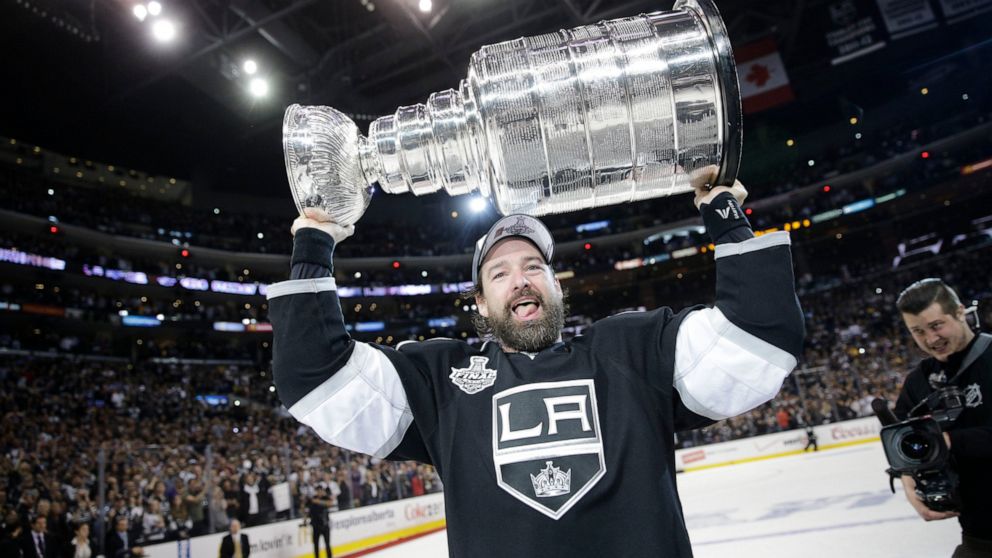 FILE - Los Angeles Kings right wing Justin Williams, of Slovenia, carries the Stanley Cup after defeating the New York Rangers in Game 5 of the NHL Stanley Cup Final series, June 13, 2014, in Los Angeles. Williams is joining NHL Network as a guest an