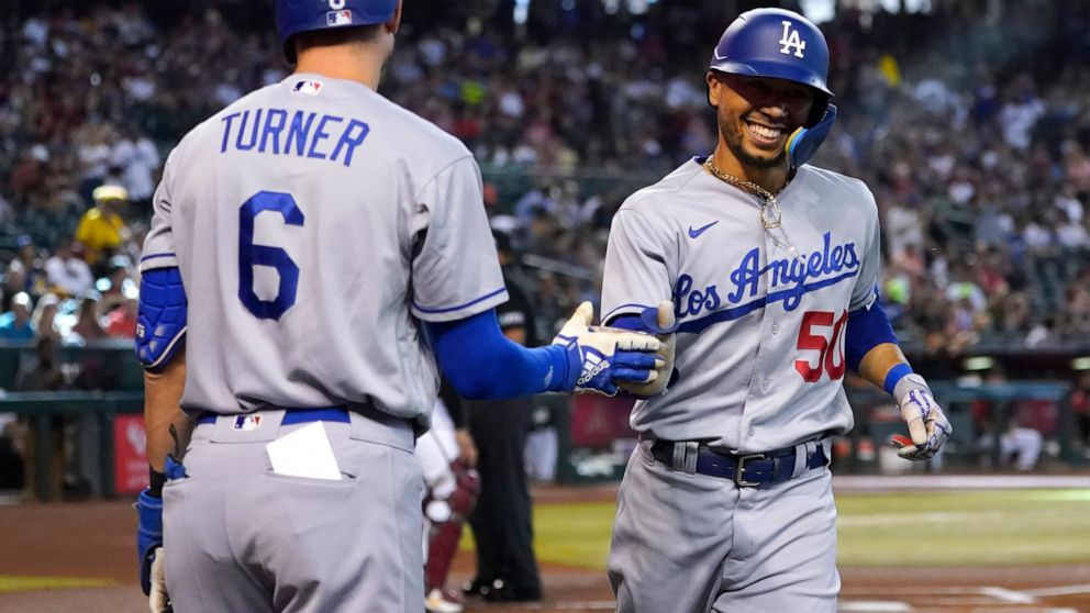 Los Angeles Dodgers' Mookie Betts (50) celebrates his solo home run against the Arizona Diamondbacks with Trea Turner during the first inning of a baseball game, Saturday, May 28, 2022, in Phoenix. (AP Photo/Matt York)