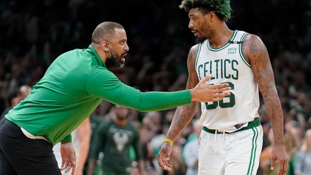 Boston Celtics head coach Ime Udoka, left, speaks with Celtics guard Marcus Smart, right, as the team leads the Milwaukee Bucks during the second half of Game 7 of an NBA basketball Eastern Conference semifinals playoff series, Sunday, May 15, 2022, 