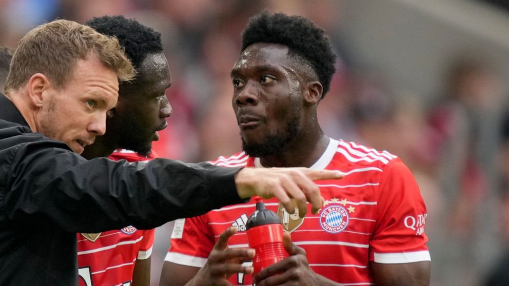 Bayern's head coach Julian Nagelsmann, left, gives instructions to Tanguy Nianzou, center, and Alphonso Davies during the German Bundesliga soccer match between Bayern Munich and Stuttgart, at the Allianz Arena, in Munich, Germany, Sunday, May 8, 202