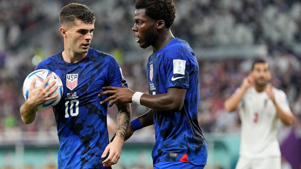 Christian Pulisic of the United States, left, and Yunus Musah of the United States speak before a free kick during the World Cup group B soccer match between Iran and the United States at the Al Thumama Stadium in Doha, Qatar, Tuesday, Nov. 29, 2022.
