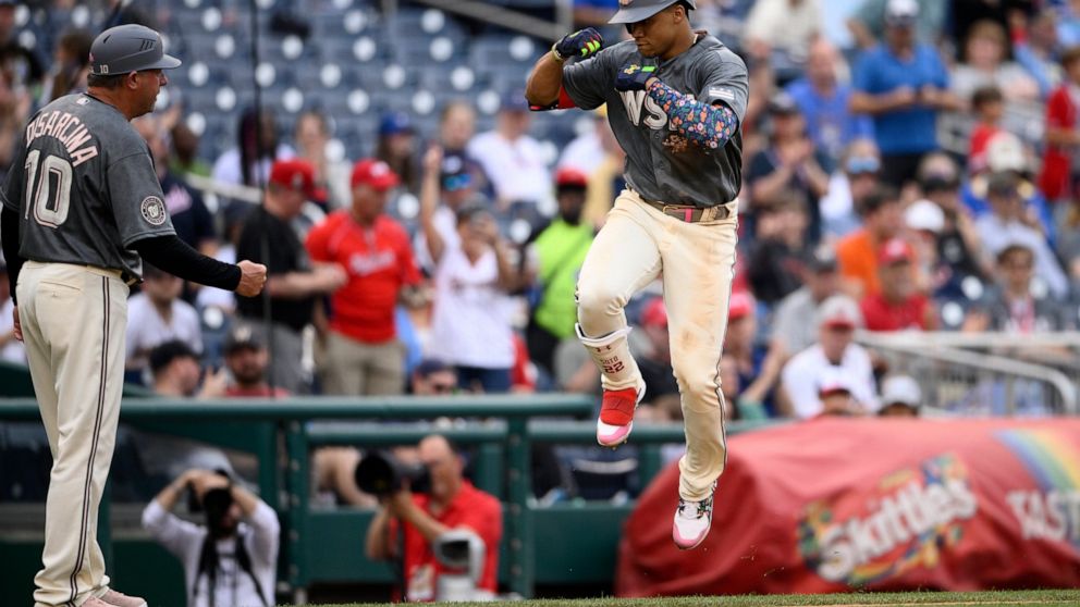 Washington Nationals' Juan Soto, right, celebrates his two-run home run with third base coach Gary Disarcina (10) as he rounds the bases during the fifth inning of a baseball game against the Milwaukee Brewers, Saturday, June 11, 2022, in Washington.