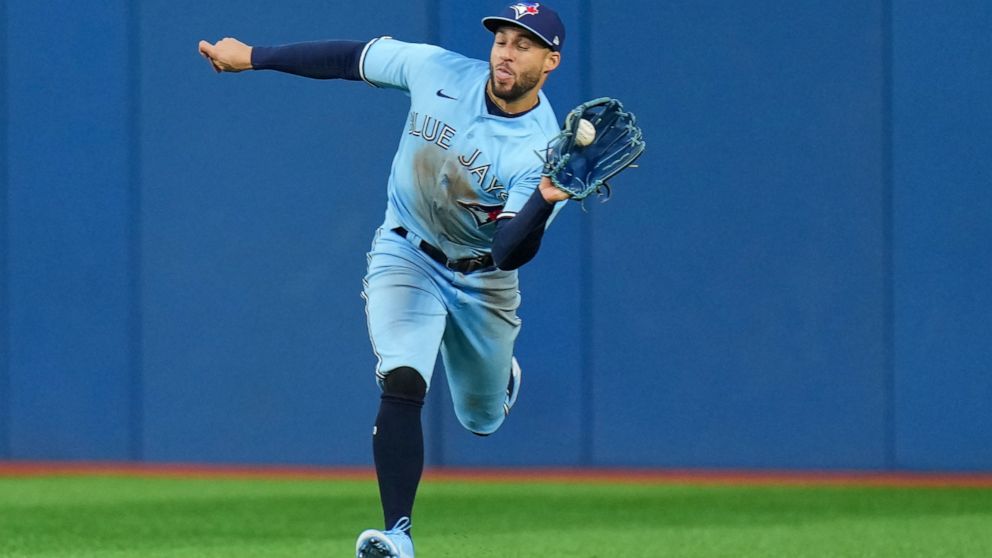 Toronto Blue Jays center fielder George Springer (4) makes a running catch to out Seattle Mariners center fielder Julio Rodriguez during the second inning of a baseball game in Toronto, Monday, May 16, 2022. (Nathan Denette/The Canadian Press via AP)