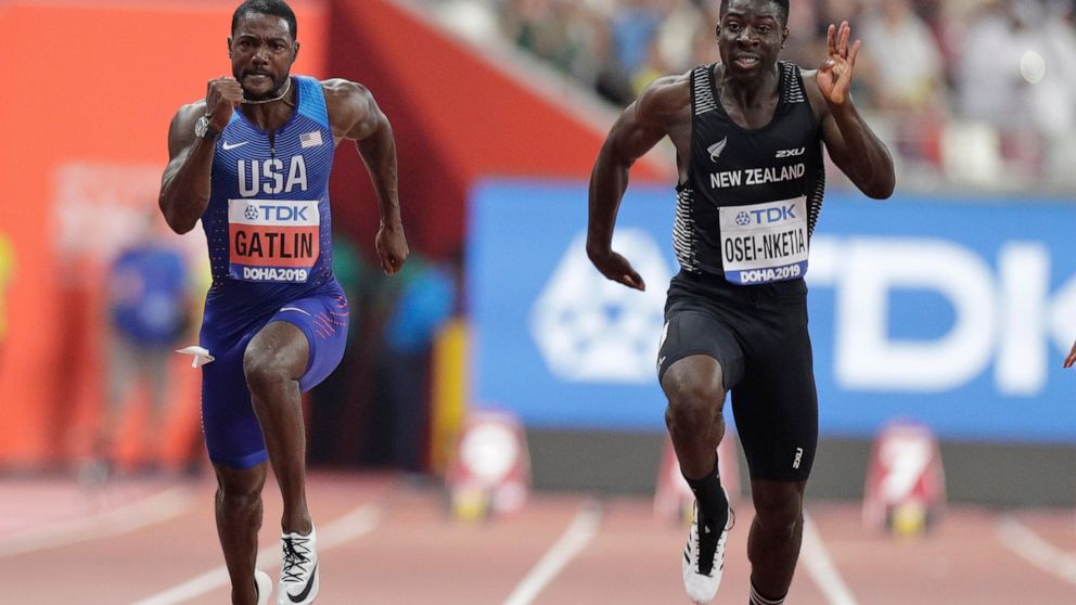 FILE - New Zealand's Edward Osei-Nketia, right, and Justin Gatlin of the United States compete during the men's 100 meters heat at the World Athletics Championships in Doha, Qatar, Sept. 27, 2019. The fastest man in New Zealand is ready to try colleg