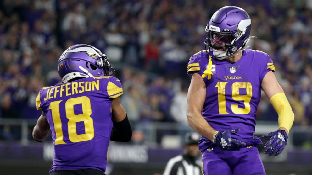 Minnesota Vikings wide receiver Adam Thielen (19) celebrates with teammate wide receiver Justin Jefferson (18) after catching a 15-yard touchdown pass during the second half of an NFL football game against the New England Patriots, Thursday, Nov. 24,