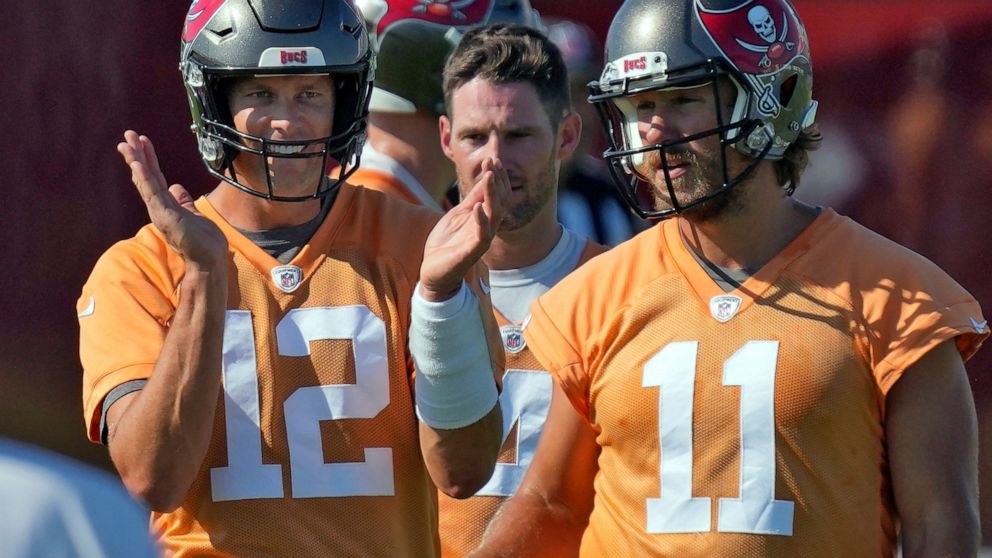 Tampa Bay Buccaneers quarterback Tom Brady (12) claps as he walks with Ryan Griffin (4) and Blaine Gabbert (11) during an NFL football minicamp Wednesday, June 8, 2022, in Tampa, Fla. (AP Photo/Chris O'Meara)