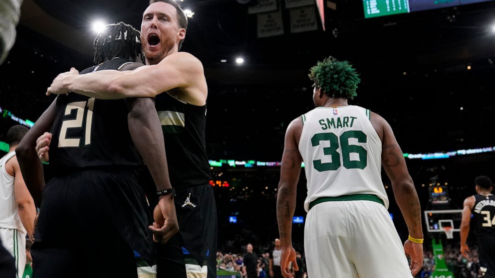 Milwaukee Bucks guard Jrue Holiday (21) is embraced by Pat Connaughton while celebrating after blocking a shot by Boston Celtics guard Marcus Smart (36) in the final seconds of play during the second half of Game 5 of an Eastern Conference semifinal 