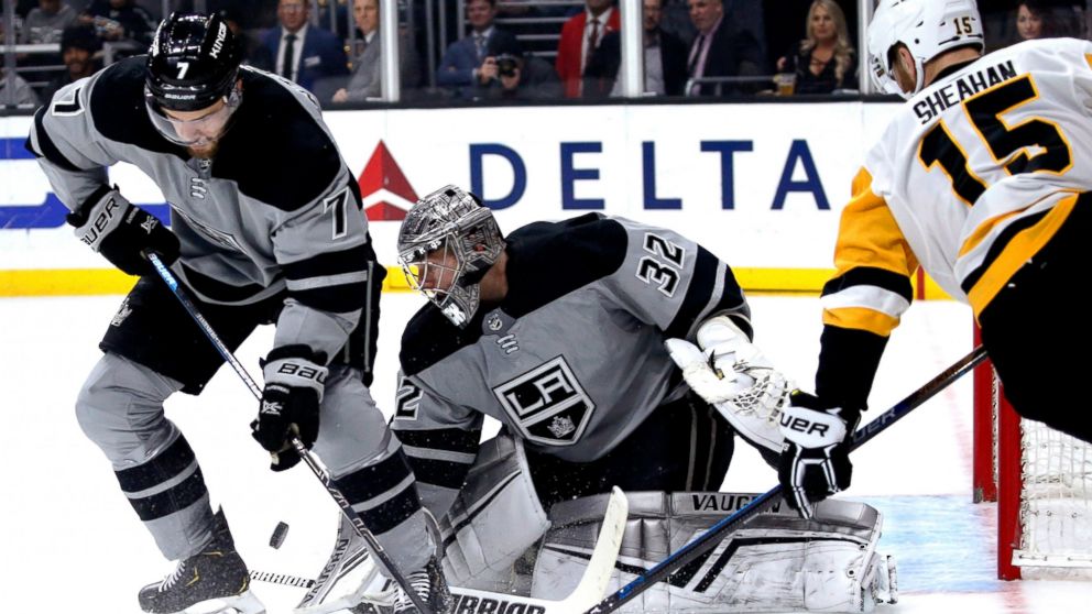 Los Angeles Kings goalie Jonathan Quick, center, protects the next while defenseman Oscar Fantenberg, left, and Pittsburgh Penguins forward Riley Sheahan try to control the puck during the first period of an NHL hockey game Saturday, Jan. 12, 2019, i