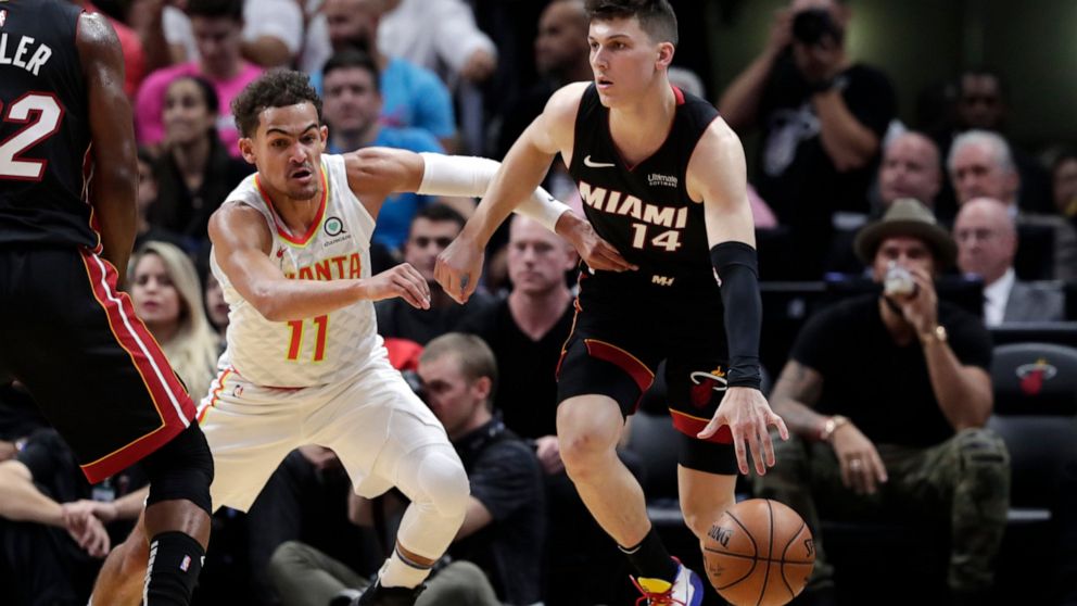 Miami Heat guard Tyler Herro (14) controls the ball as Atlanta Hawks guard Trae Young (11) defends during the first half of an NBA basketball game, Tuesday, Dec. 10, 2019, in Miami. (AP Photo/Lynne Sladky)