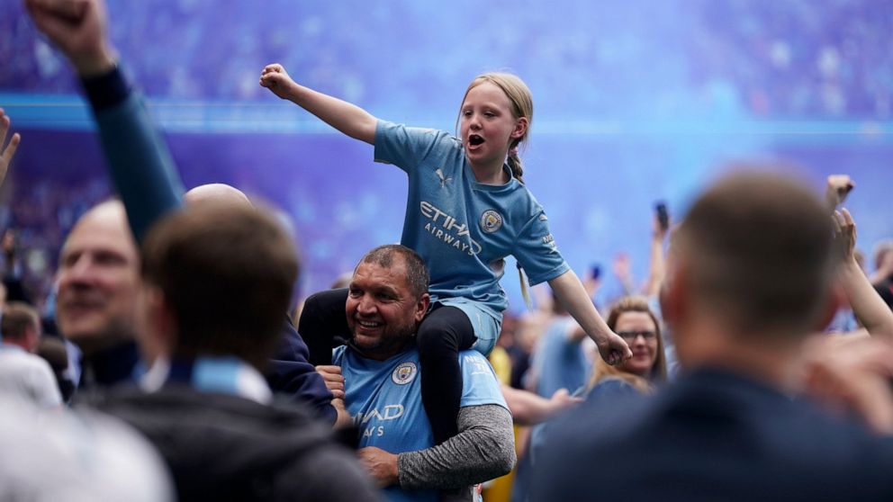 Manchester City fans celebrate after the English Premier League soccer match between Manchester City and Aston Villa at the Etihad Stadium in Manchester, England, Sunday, May 22, 2022. Manchester City won the match against Aston Villa and secured the