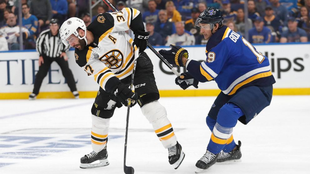 Boston Bruins center Patrice Bergeron (37) passes the puck away from St. Louis Blues defenseman Jay Bouwmeester (19) during the first period of Game 3 of the NHL hockey Stanley Cup Final Saturday, June 1, 2019, in St. Louis. (AP Photo/Jeff Roberson)