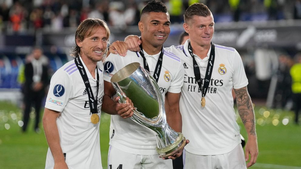 Real Madrid's Luka Modric, left, Real Madrid's Toni Kroos, right, and Real Madrid's Casemiro pose for a photograph as celebrate with the trophy after winning the UEFA Super Cup final soccer match between Real Madrid and Eintracht Frankfurt at Helsink