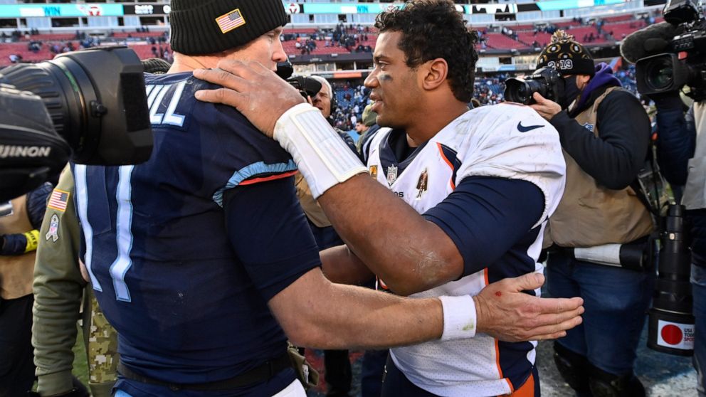 Tennessee Titans quarterback Ryan Tannehill speaks with Denver Broncos quarterback Russell Wilson after an NFL football game, Sunday, Nov. 13, 2022, in Nashville, Tenn. The Tennessee Titans won 17-10. (AP Photo/Mark Zaleski)