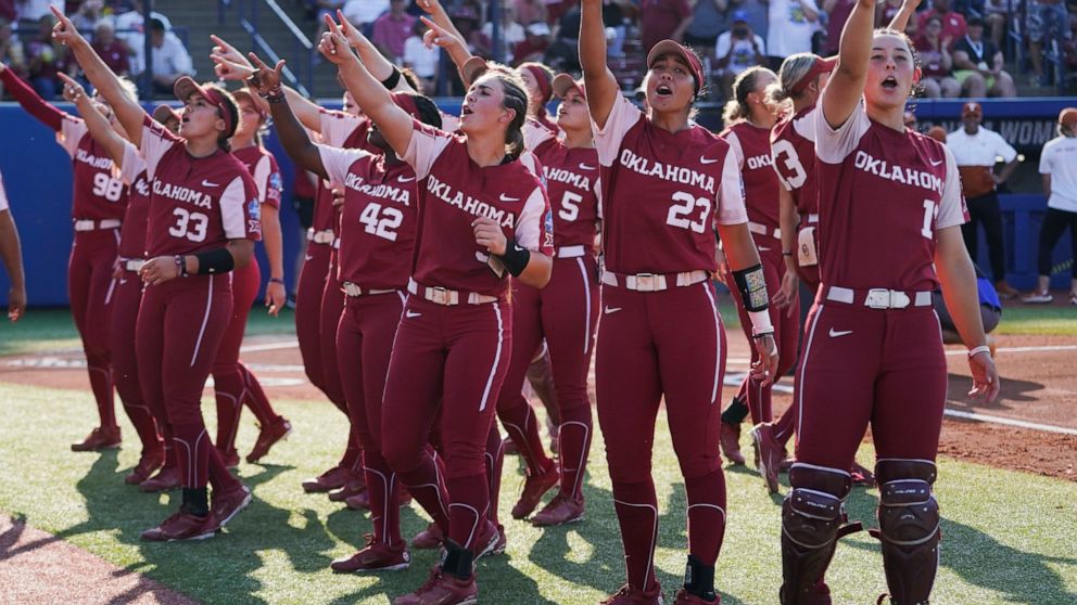 Oklahoma players gesture to fans before the second game of the NCAA Women's College World Series softball championship series against Texas, Thursday, June 9, 2022, in Oklahoma City. (AP Photo/Sue Ogrocki)