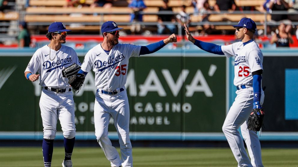 Los Angeles Dodgers' Cody Bellinger (35) celebrates with Trayce Thompson (25) and Miguel Vargas after the Dodgers defeated the Arizona Diamondbacks in a baseball game Tuesday, Sept 20, 2022, in Los Angeles. (AP Photo/Ringo H.W. Chiu)
