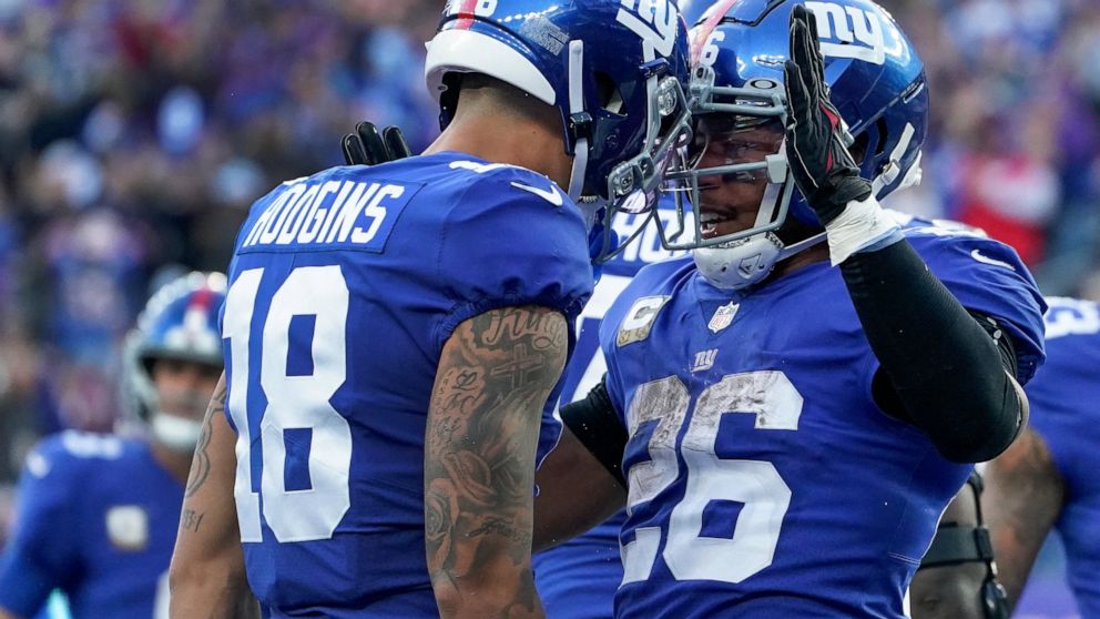 New York Giants running back Saquon Barkley (26) celebrates with wide receiver Isaiah Hodgins after scoring a touchdown against the Houston Texans during the fourth quarter of an NFL football game, Sunday, Nov. 13, 2022, in East Rutherford, N.J. (AP 