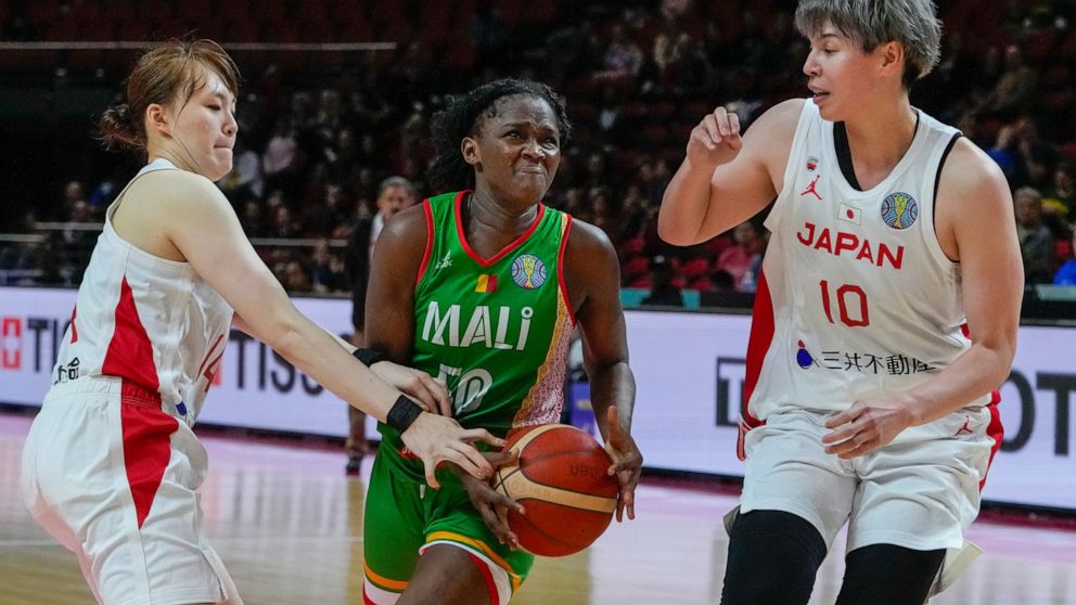 Japan's Mai Yoshida, left, and Japan's Ramu Tokashiki, right, attempt to block a shot at goal by Mali's Djeneba N'Diaye during their game at the women's Basketball World Cup in Sydney, Australia, Thursday, Sept. 22, 2022. (AP Photo/Mark Baker)