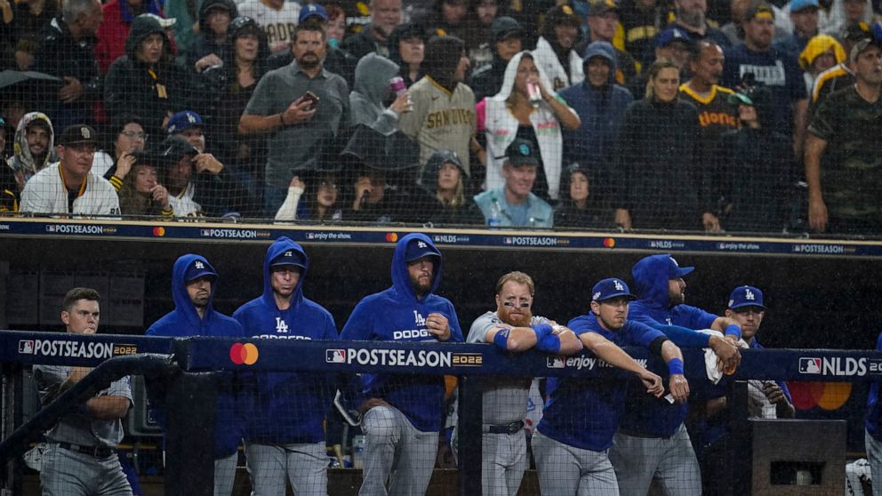 Members of the Los Angeles Dodgers look on from the dugout during the ninth inning in Game 4 of a baseball NL Division Series against the San Diego Padres, Saturday, Oct. 15, 2022, in San Diego. (AP Photo/Ashley Landis)